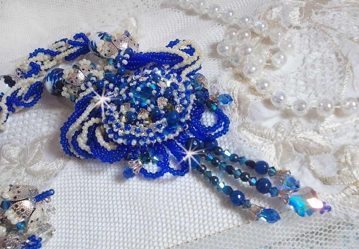 Collier Lotus Flowers avec un cabochon en Verre brod&eacute; sur une base en su&eacute;dine &agrave; laquelle s&rsquo;ajoute :  perles de Venise, coupelles estampes, toupies, chatons, gouttes, rocailles et fermoir Argent 925