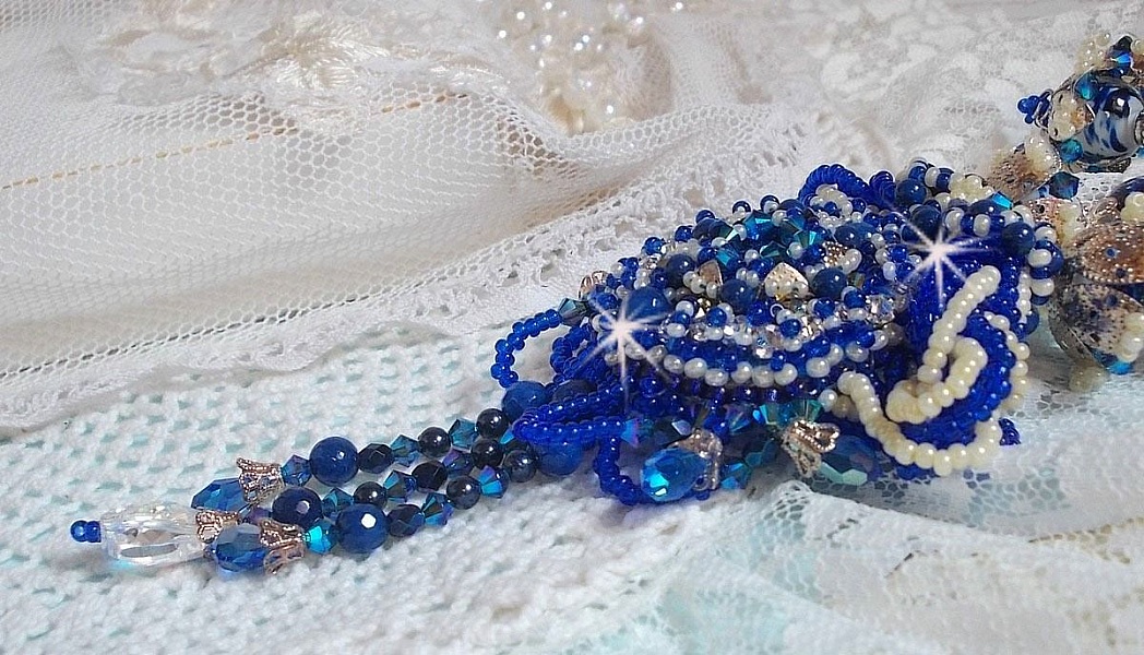 Collier Lotus Flowers avec un cabochon en Verre brod&eacute; sur une base en su&eacute;dine &agrave; laquelle s&rsquo;ajoute :  perles de Venise, coupelles estampes, toupies, chatons, gouttes, rocailles et fermoir Argent 925