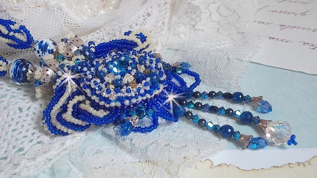 Collier Lotus Flowers avec un cabochon en Verre brod&eacute; sur une base en su&eacute;dine &agrave; laquelle s&rsquo;ajoute :  perles de Venise, coupelles estampes, toupies, chatons, gouttes, rocailles et fermoir Argent 925
