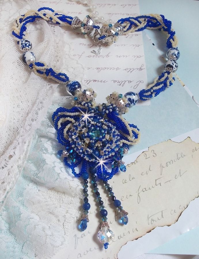 Collier Lotus Flowers avec un cabochon en Verre brod&eacute; sur une base en su&eacute;dine &agrave; laquelle s&rsquo;ajoute :  perles de Venise, coupelles estampes, toupies, chatons, gouttes, rocailles et fermoir Argent 925