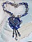 Collier Lotus Flowers avec un cabochon en Verre brod&eacute; sur une base en su&eacute;dine &agrave; laquelle s&rsquo;ajoute :  perles de Venise, coupelles estampes, toupies, chatons, gouttes, rocailles et fermoir Argent 925