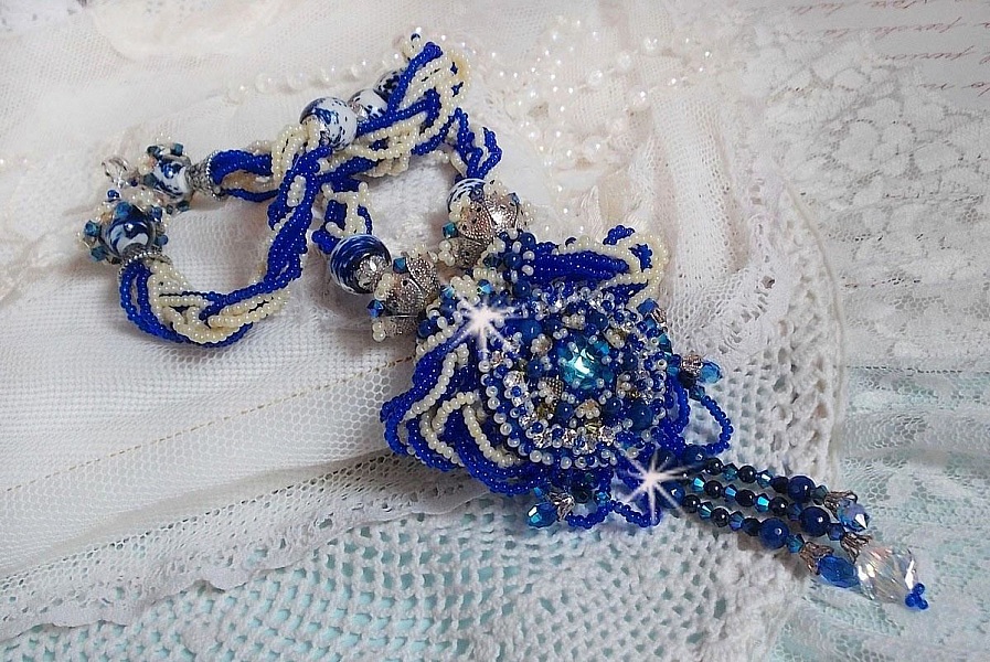Collier Lotus Flowers avec un cabochon en Verre brod&eacute; sur une base en su&eacute;dine &agrave; laquelle s&rsquo;ajoute :  perles de Venise, coupelles estampes, toupies, chatons, gouttes, rocailles et fermoir Argent 925
