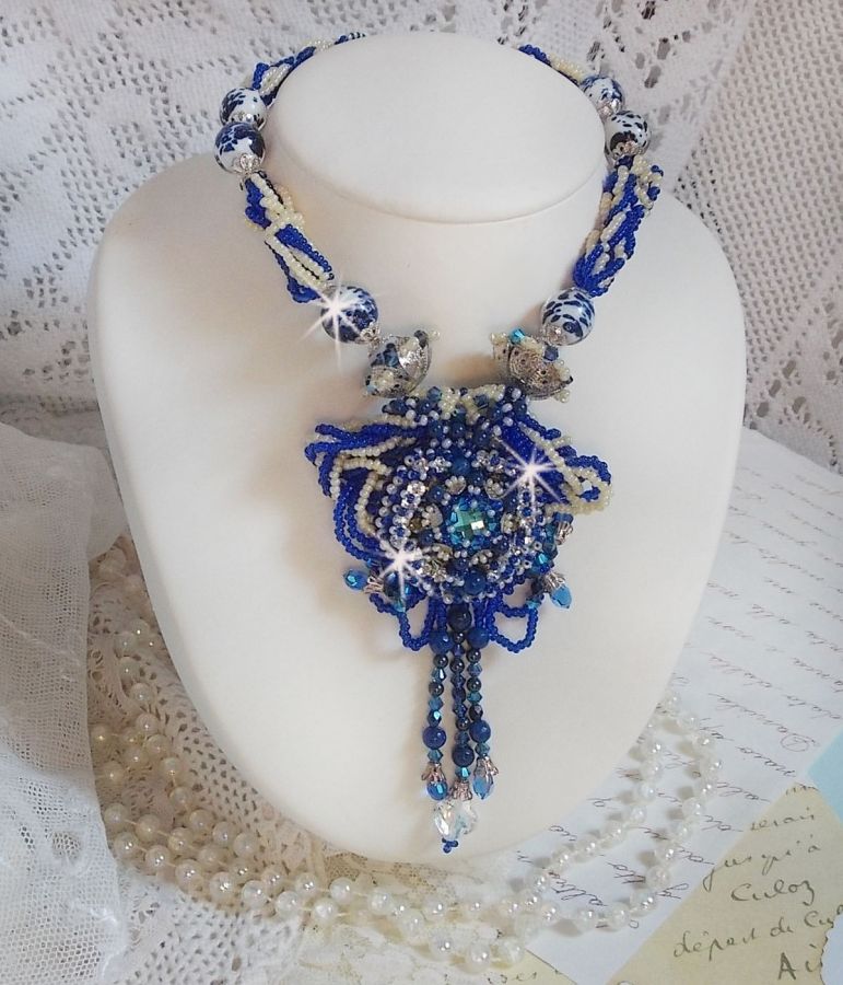 Collier Lotus Flowers avec un cabochon en Verre brod&eacute; sur une base en su&eacute;dine &agrave; laquelle s&rsquo;ajoute :  perles de Venise, coupelles estampes, toupies, chatons, gouttes, rocailles et fermoir Argent 925