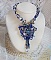 Collier Lotus Flowers avec un cabochon en Verre brod&eacute; sur une base en su&eacute;dine &agrave; laquelle s&rsquo;ajoute :  perles de Venise, coupelles estampes, toupies, chatons, gouttes, rocailles et fermoir Argent 925