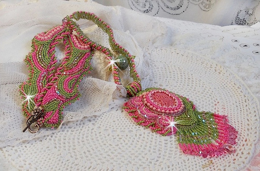 Collier Miss Lady brod&eacute; avec un cabochon repr&eacute;sentant des fleurs de couleur Rose Pink &agrave; laquelle s'ajoute perles rondes, toupies en Cristal, facettes, rocailles Anis, Rose et perle c&eacute;ramique 