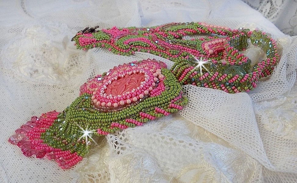 Collier Miss Lady brod&eacute; avec un cabochon repr&eacute;sentant des fleurs de couleur Rose Pink &agrave; laquelle s'ajoute perles rondes, toupies en Cristal, facettes, rocailles Anis, Rose et perle c&eacute;ramique 