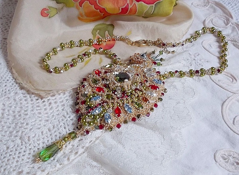 Collier L&rsquo;Oiseau des Iles brod&eacute; fa&ccedil;on Art Nouveau sur une su&eacute;dine avec une estampe o&ugrave; se niche diff&eacute;rents cristaux de tailles et couleurs diff&eacute;rentes, des rocailles Miyuki et des perles Antiques 