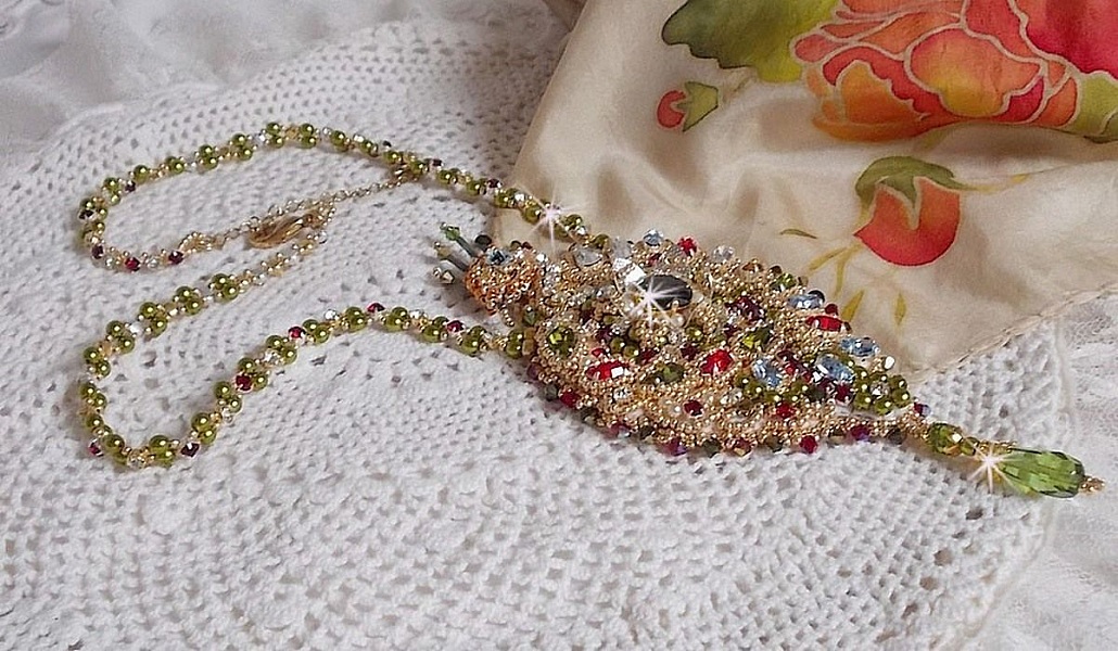 Collier L&rsquo;Oiseau des Iles brod&eacute; fa&ccedil;on Art Nouveau sur une su&eacute;dine avec une estampe o&ugrave; se niche diff&eacute;rents cristaux de tailles et couleurs diff&eacute;rentes, des rocailles Miyuki et des perles Antiques 