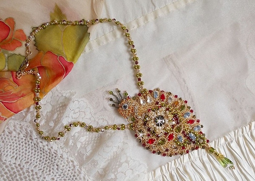 Collier L&rsquo;Oiseau des Iles brod&eacute; fa&ccedil;on Art Nouveau sur une su&eacute;dine avec une estampe o&ugrave; se niche diff&eacute;rents cristaux de tailles et couleurs diff&eacute;rentes, des rocailles Miyuki et des perles Antiques 
