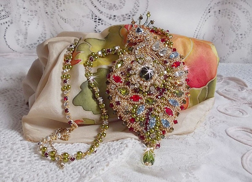 Collier L&rsquo;Oiseau des Iles brod&eacute; fa&ccedil;on Art Nouveau sur une su&eacute;dine avec une estampe o&ugrave; se niche diff&eacute;rents cristaux de tailles et couleurs diff&eacute;rentes, des rocailles Miyuki et des perles Antiques 