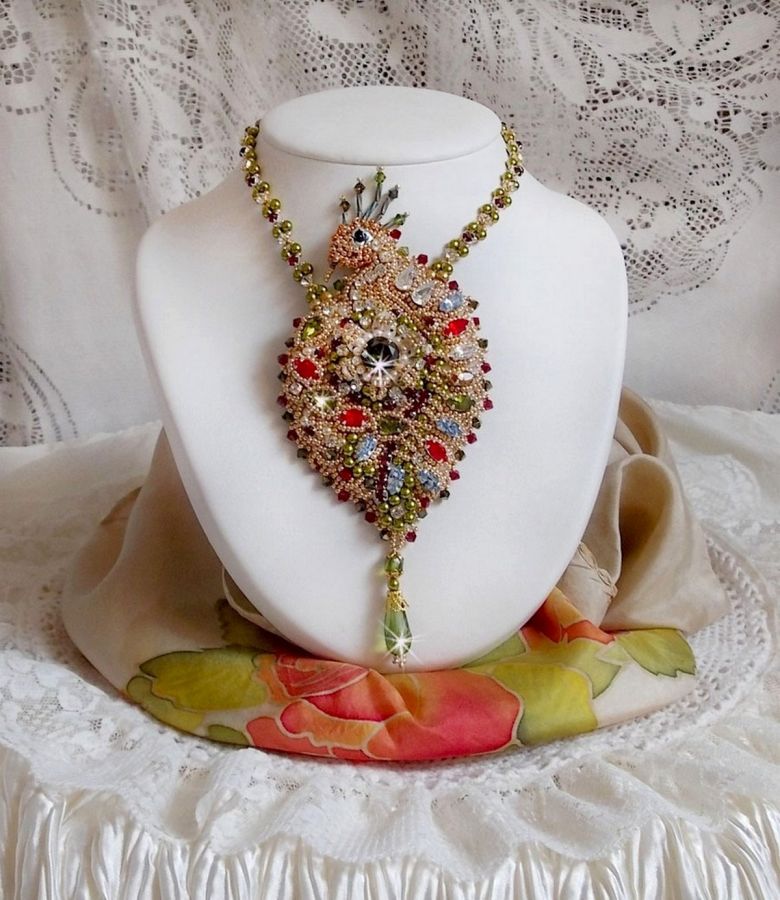 Collier L&rsquo;Oiseau des Iles brod&eacute; fa&ccedil;on Art Nouveau sur une su&eacute;dine avec une estampe o&ugrave; se niche diff&eacute;rents cristaux de tailles et couleurs diff&eacute;rentes, des rocailles Miyuki et des perles Antiques 