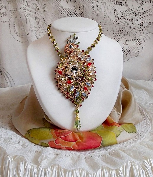 Collier L&rsquo;Oiseau des Iles brod&eacute; fa&ccedil;on Art Nouveau sur une su&eacute;dine avec une estampe o&ugrave; se niche diff&eacute;rents cristaux de tailles et couleurs diff&eacute;rentes, des rocailles Miyuki et des perles Antiques 