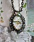 Collier Oiseau des Jardins s&rsquo;inspire d&rsquo;un oiseau dans la nature. Sur une base d&rsquo;un pendentif, ce motif est orn&eacute; de cristaux : n&oelig;ud et cabochons aux nuances cristal et P&eacute;ridot. Mont&eacute; sur cha&icirc;ne Laiton