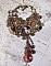 Collier Mes Passions Broc's cr&eacute;&eacute;e une femme aux cheveux dor&eacute;s avec des fleurs, des accessoires de couleur Bronze, des breloques des cristaux et une cha&icirc;ne strass