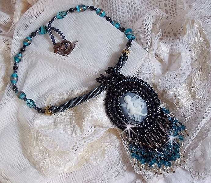 Pendentif Angelot avec un cabochon Ange brod&eacute; de perles rondes nacr&eacute;es Cristal avec des rocailles. S&rsquo;ajoute des facettes, toupies, perles ovales Lampwok serti d&rsquo;un ruban Dor&eacute; et palets