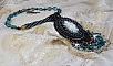 Pendentif Angelot avec un cabochon Ange brod&eacute; de perles rondes nacr&eacute;es Cristal avec des rocailles. S&rsquo;ajoute des facettes, toupies, perles ovales Lampwok serti d&rsquo;un ruban Dor&eacute; et palets