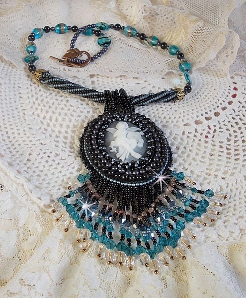 Pendentif Angelot avec un cabochon Ange brod&eacute; de perles rondes nacr&eacute;es Cristal avec des rocailles. S&rsquo;ajoute des facettes, toupies, perles ovales Lampwok serti d&rsquo;un ruban Dor&eacute; et palets
