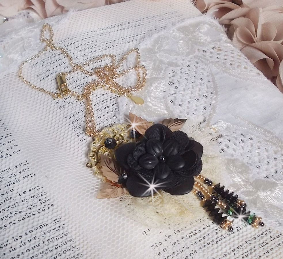 Pendentif Attrapes R&ecirc;ves brod&eacute; avec des fleurs Lucites Noires sur une dentelle Beige et une estampe dor&eacute;e. Les pendants sont des fleurs en cristal avec des rocailles. Mont&eacute; avec une cha&icirc;ne plaqu&eacute; Or