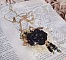 Pendentif Attrapes R&ecirc;ves brod&eacute; avec des fleurs Lucites Noires sur une dentelle Beige et une estampe dor&eacute;e. Les pendants sont des fleurs en cristal avec des rocailles. Mont&eacute; avec une cha&icirc;ne plaqu&eacute; Or