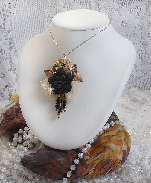 Pendentif Attrapes R&ecirc;ves brod&eacute; avec des fleurs Lucites Noires sur une dentelle Beige et une estampe dor&eacute;e. Les pendants sont des fleurs en cristal avec des rocailles. Mont&eacute; avec une cha&icirc;ne plaqu&eacute; Or