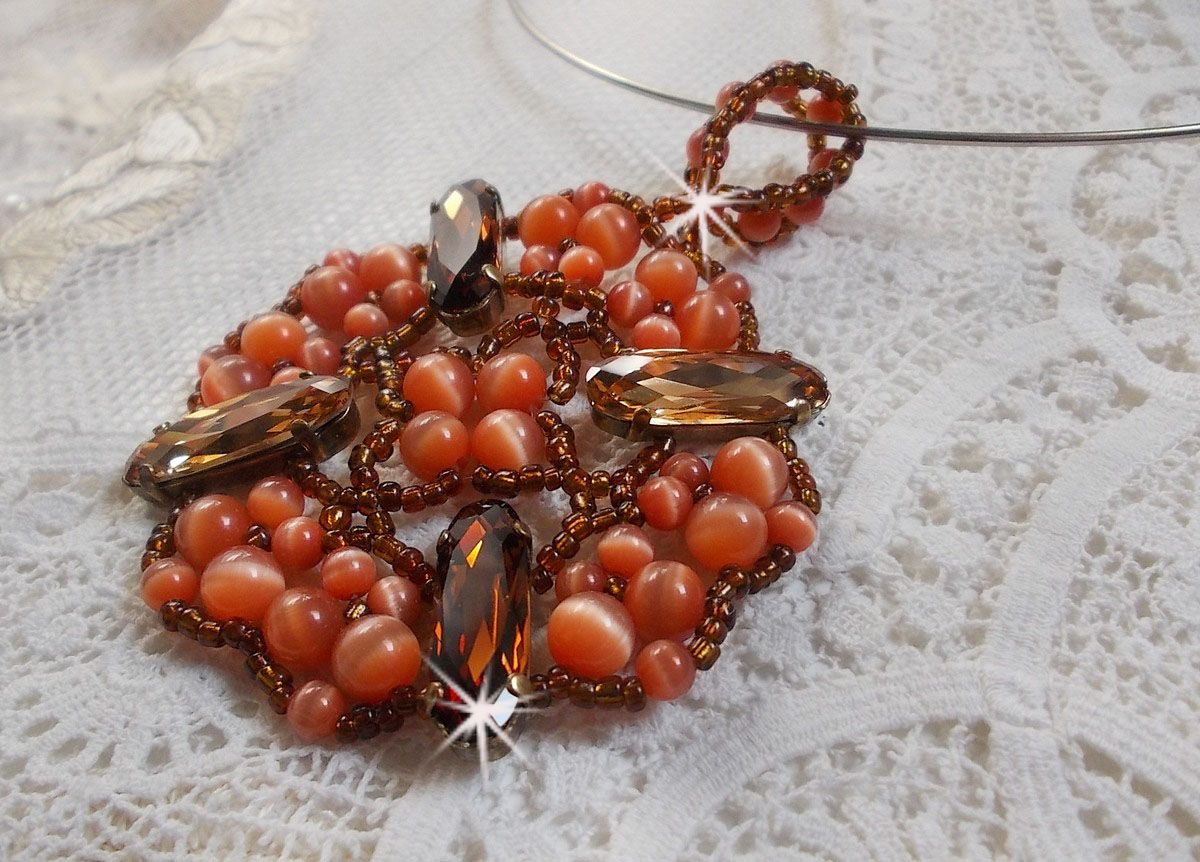 Pendentif D&rsquo;Automne mont&eacute; avec des cabochons ovales allong&eacute;s facett&eacute;s en Cristal aux couleurs : Topaze et Light Colorado Topaze &agrave; laquelle s&rsquo;ajoute des perles rondes &oelig;il de chat et rocailles