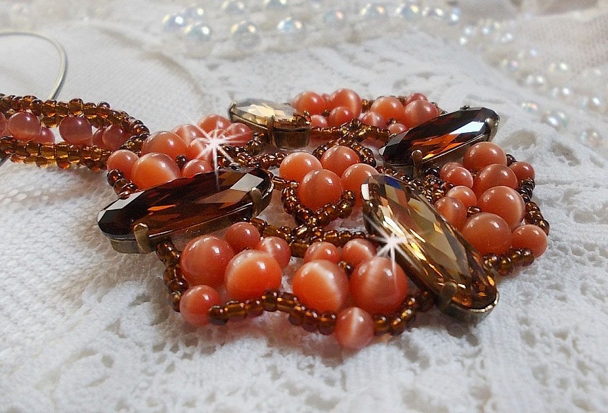 Pendentif D&rsquo;Automne mont&eacute; avec des cabochons ovales allong&eacute;s facett&eacute;s en Cristal aux couleurs : Topaze et Light Colorado Topaze &agrave; laquelle s&rsquo;ajoute des perles rondes &oelig;il de chat et rocailles