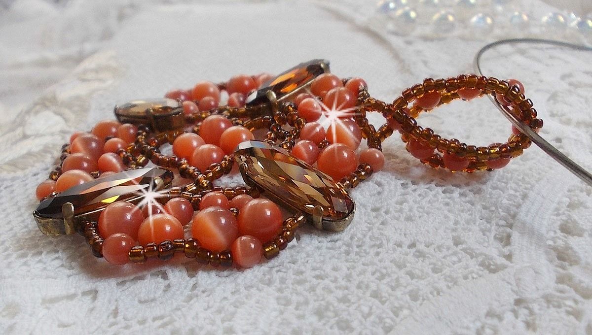Pendentif D&rsquo;Automne mont&eacute; avec des cabochons ovales allong&eacute;s facett&eacute;s en Cristal aux couleurs : Topaze et Light Colorado Topaze &agrave; laquelle s&rsquo;ajoute des perles rondes &oelig;il de chat et rocailles