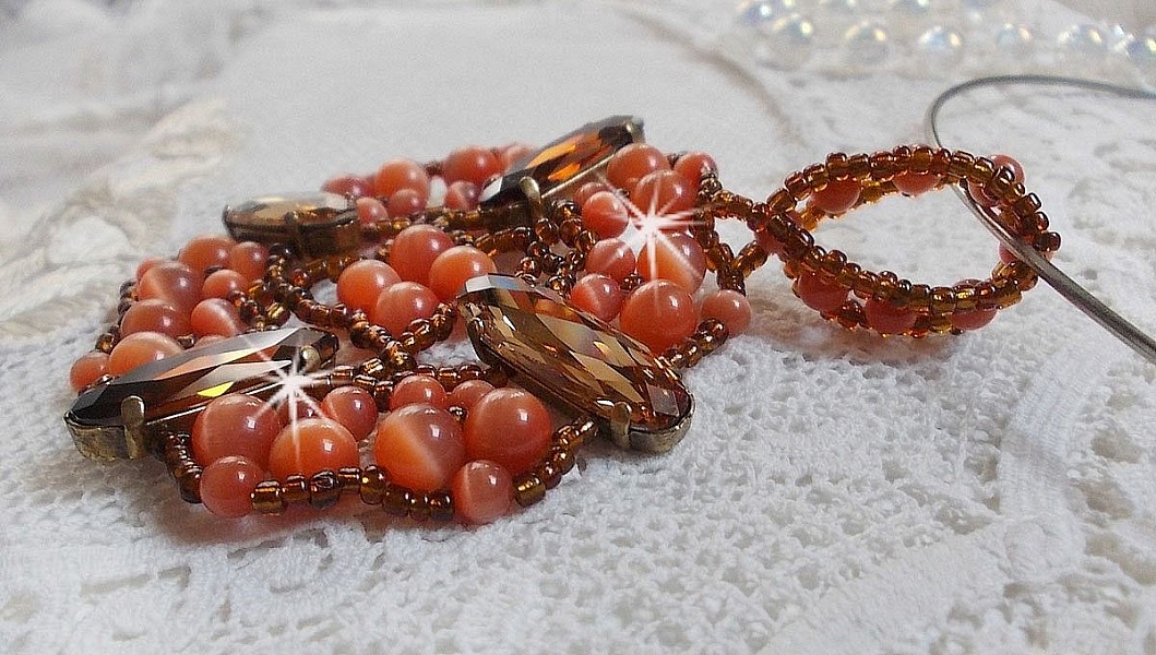 Pendentif D&rsquo;Automne mont&eacute; avec des cabochons ovales allong&eacute;s facett&eacute;s en Cristal aux couleurs : Topaze et Light Colorado Topaze &agrave; laquelle s&rsquo;ajoute des perles rondes &oelig;il de chat et rocailles