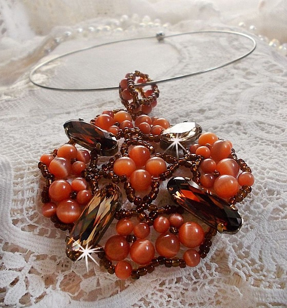 Pendentif D&rsquo;Automne mont&eacute; avec des cabochons ovales allong&eacute;s facett&eacute;s en Cristal aux couleurs : Topaze et Light Colorado Topaze &agrave; laquelle s&rsquo;ajoute des perles rondes &oelig;il de chat et rocailles