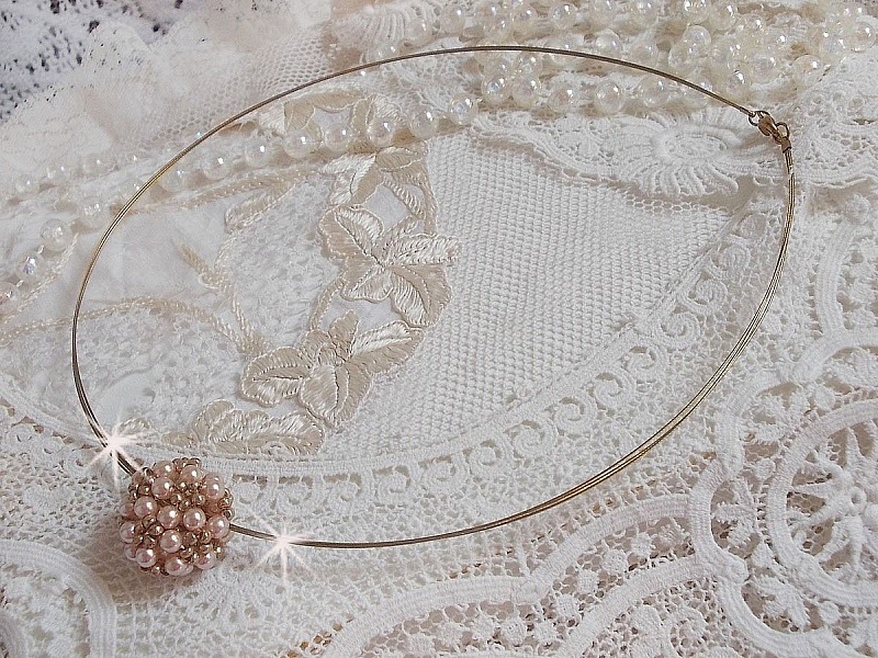 Pendentif Boules nacr&eacute;es avec des perles rondes en cristal de Swarovski de couleur P&ecirc;che et des rocailles en Verre Gold Bronze. Le tour du cou multi rangs est compos&eacute; de 3 rangs fil c&acirc;bl&eacute; en laiton.