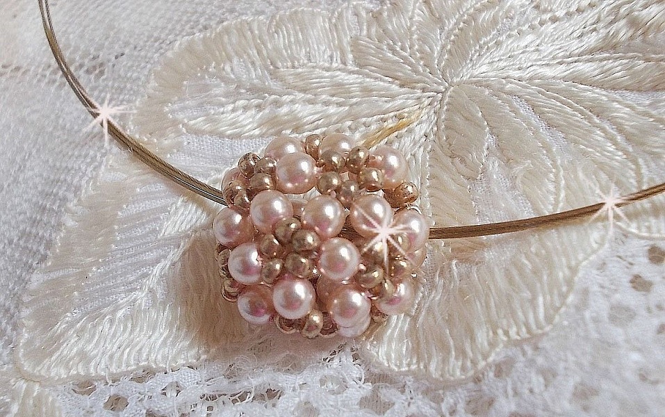 Pendentif Boules nacr&eacute;es avec des perles rondes en cristal de Swarovski de couleur P&ecirc;che et des rocailles en Verre Gold Bronze. Le tour du cou multi rangs est compos&eacute; de 3 rangs fil c&acirc;bl&eacute; en laiton.