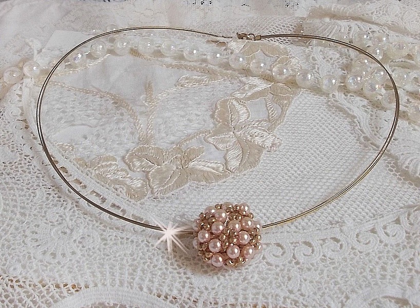 Pendentif Boules nacr&eacute;es avec des perles rondes en cristal de Swarovski de couleur P&ecirc;che et des rocailles en Verre Gold Bronze. Le tour du cou multi rangs est compos&eacute; de 3 rangs fil c&acirc;bl&eacute; en laiton.
