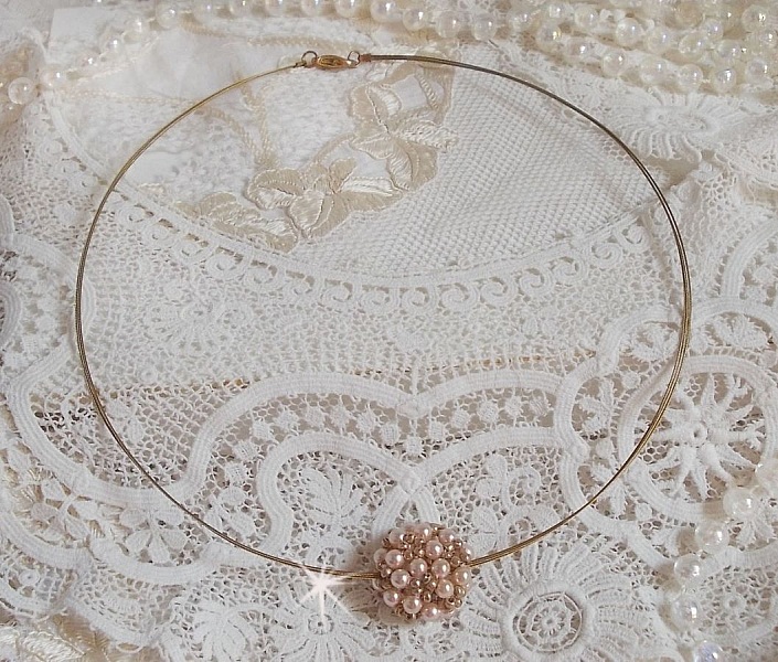 Pendentif Boules nacr&eacute;es avec des perles rondes en cristal de Swarovski de couleur P&ecirc;che et des rocailles en Verre Gold Bronze. Le tour du cou multi rangs est compos&eacute; de 3 rangs fil c&acirc;bl&eacute; en laiton.