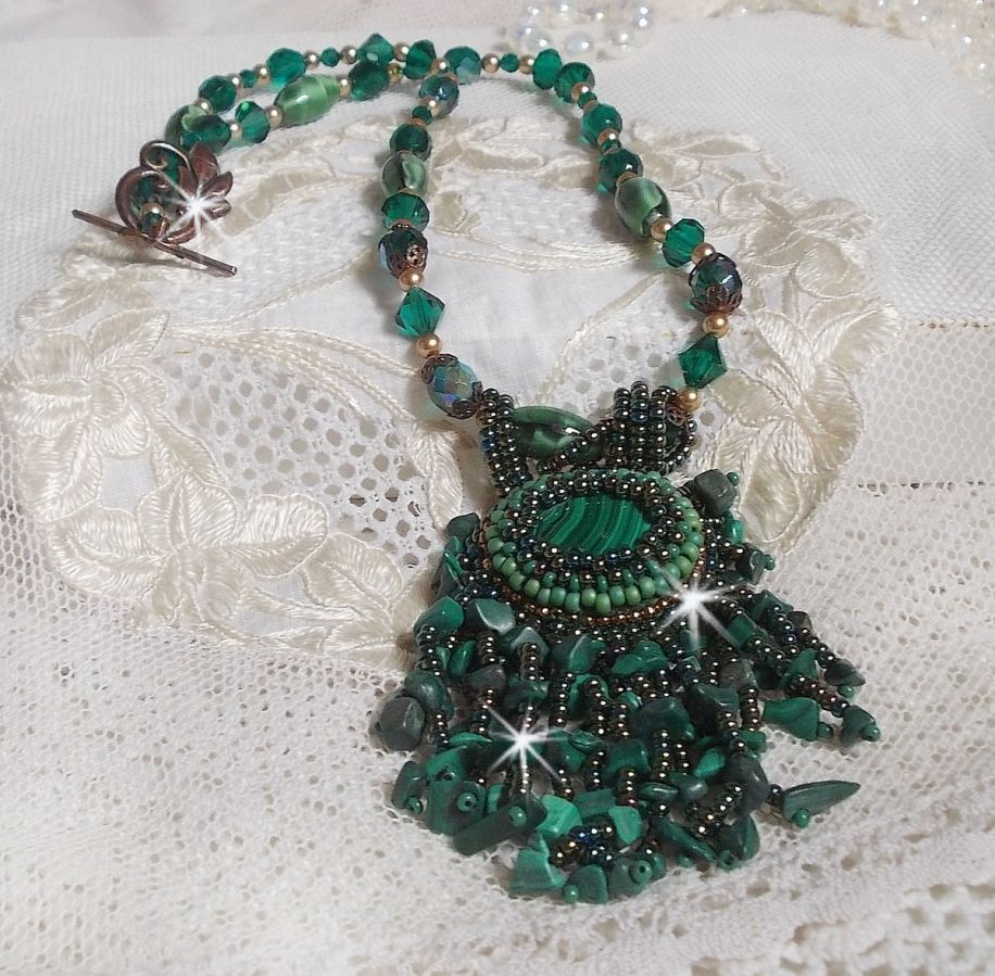 Pendentif Emerald avec un cabochon ovale en Malachite orn&eacute; de chips avec cristaux : perles rondes et toupies Emerald. S&rsquo;ajoute des perles en forme d&rsquo;olives. Brod&eacute;s sur fermoir en T. Un style Ethnique