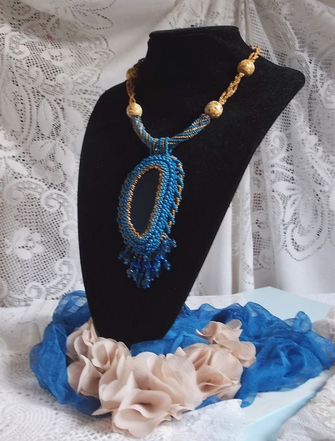 Pendentif Corsica avec un cabochon : une Agate Bleue brod&eacute;e avec des perles nacr&eacute;es Bleu Lapis en cristal &agrave; laquelle s&rsquo;ajoute des rocailles saphir et travertin entrelac&eacute;es pour former une dentelle