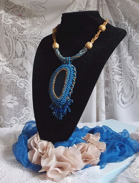 Pendentif Corsica avec un cabochon : une Agate Bleue brod&eacute;e avec des perles nacr&eacute;es Bleu Lapis en cristal &agrave; laquelle s&rsquo;ajoute des rocailles saphir et travertin entrelac&eacute;es pour former une dentelle