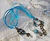 Pendentif Lady in Blue mont&eacute; avec des chandeliers, des cristaux : cabochons, perles rondes et toupies, perles en c&eacute;ramique, cabochons Zirconium, rocailles et rubans. Tout est de couleur Bleu et Bronze