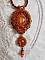 Pendentif brodé orange et doré avec cabochon en cristal.