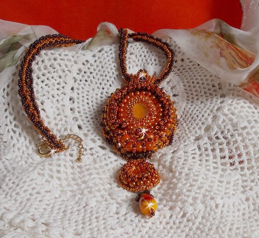 Pendentif brodé de perles orange et marron style contemporain.