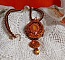 Pendentif brodé de perles orange et marron style contemporain.