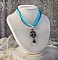 Pendentif Lady in Blue mont&eacute; avec des chandeliers, des cristaux : cabochons, perles rondes et toupies, perles en c&eacute;ramique, cabochons Zirconium, rocailles et rubans. Tout est de couleur Bleu et Bronze