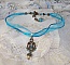 Pendentif Lady in Blue mont&eacute; avec des chandeliers, des cristaux : cabochons, perles rondes et toupies, perles en c&eacute;ramique, cabochons Zirconium, rocailles et rubans. Tout est de couleur Bleu et Bronze