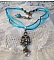 Pendentif Lady in Blue mont&eacute; avec des chandeliers, des cristaux : cabochons, perles rondes et toupies, perles en c&eacute;ramique, cabochons Zirconium, rocailles et rubans. Tout est de couleur Bleu et Bronze