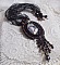 Pendentif Midnight Daisy avec un cabochon en bois repr&eacute;sentant une femme en chapeau Bleu, brod&eacute; avec des fleurs lucites, coupelles et facettes. Le tout est fini avec une dentelle Noire et un ruban