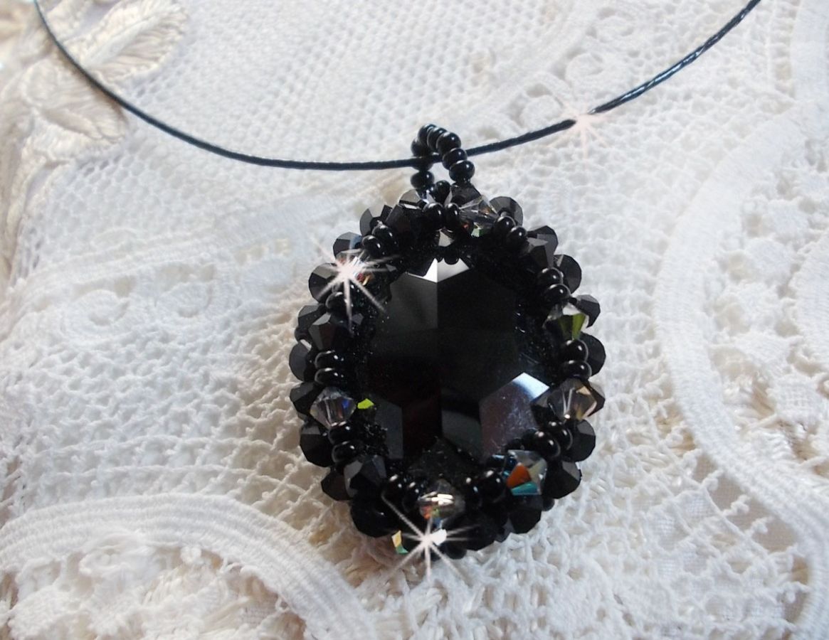 Pendentif Mirano incarne parfaitement l&rsquo;&eacute;l&eacute;gance avec un cabochon ovale facett&eacute; en Cristal cercl&eacute; de rocailles et toupies aux couleurs Noires et Argent&eacute;es. Mont&eacute; sur un tour du cou c&acirc;bl&eacute; et cir&eacute; Noir 