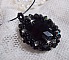 Pendentif Mirano incarne parfaitement l&rsquo;&eacute;l&eacute;gance avec un cabochon ovale facett&eacute; en Cristal cercl&eacute; de rocailles et toupies aux couleurs Noires et Argent&eacute;es. Mont&eacute; sur un tour du cou c&acirc;bl&eacute; et cir&eacute; Noir 