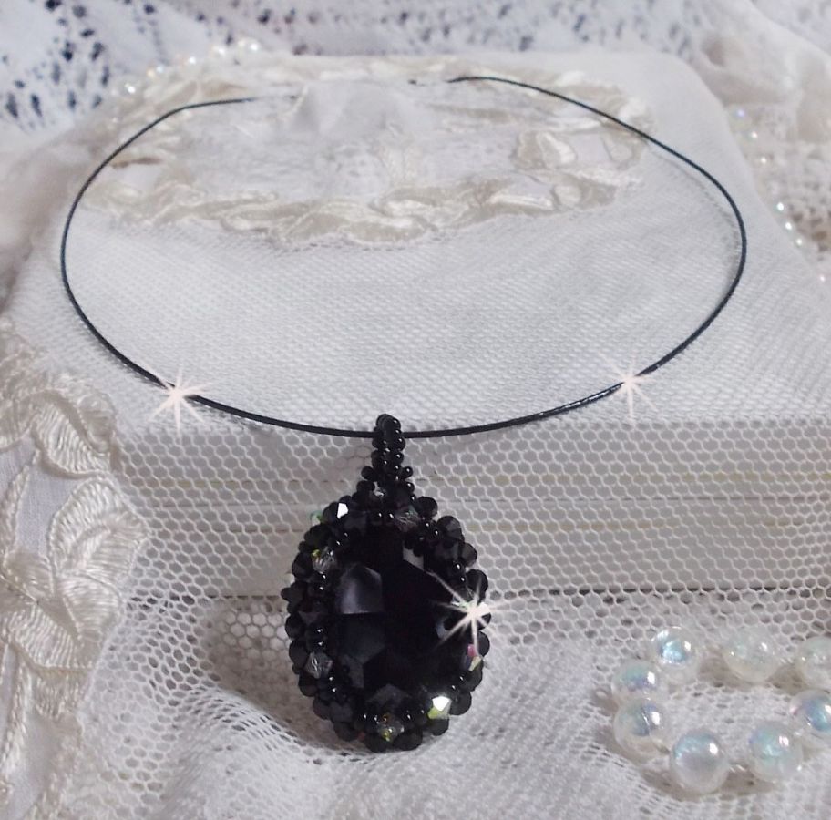 Pendentif Mirano incarne parfaitement l&rsquo;&eacute;l&eacute;gance avec un cabochon ovale facett&eacute; en Cristal cercl&eacute; de rocailles et toupies aux couleurs Noires et Argent&eacute;es. Mont&eacute; sur un tour du cou c&acirc;bl&eacute; et cir&eacute; Noir 