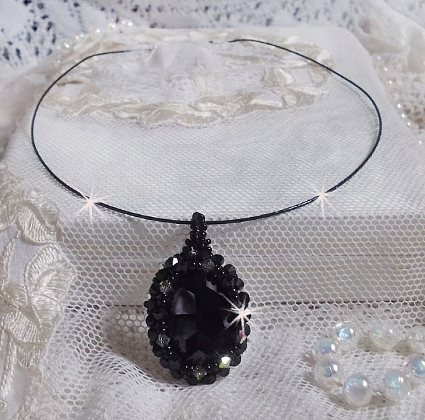 Pendentif Mirano incarne parfaitement l&rsquo;&eacute;l&eacute;gance avec un cabochon ovale facett&eacute; en Cristal cercl&eacute; de rocailles et toupies aux couleurs Noires et Argent&eacute;es. Mont&eacute; sur un tour du cou c&acirc;bl&eacute; et cir&eacute; Noir 
