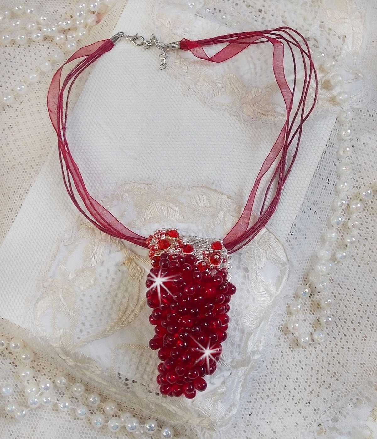 Pendentif Tendre Rouge mont&eacute; avec des gouttes en verre rouge, des perles rondes facett&eacute;es et des perles nacr&eacute;es