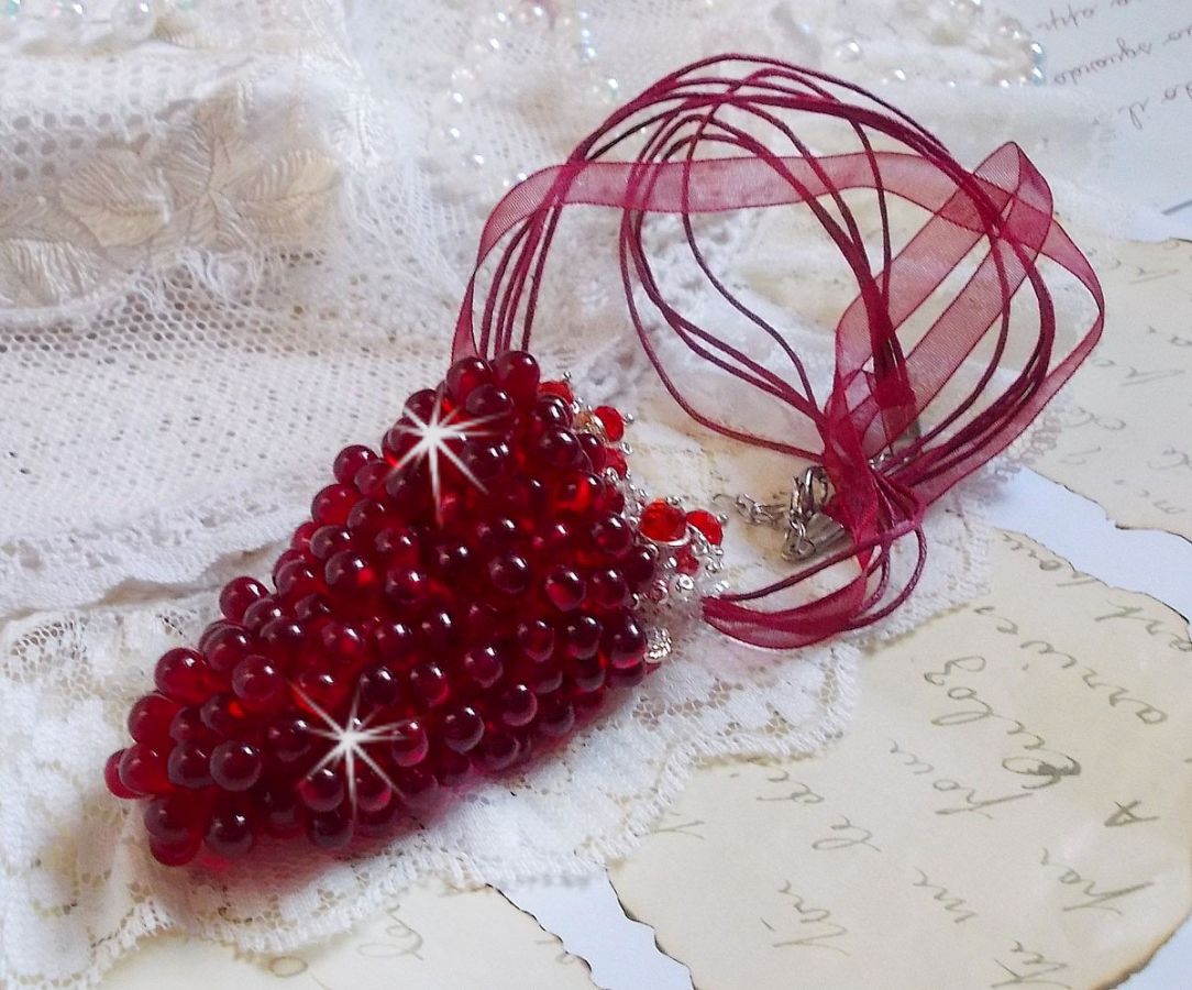 Pendentif Tendre Rouge mont&eacute; avec des gouttes en verre rouge, des perles rondes facett&eacute;es et des perles nacr&eacute;es